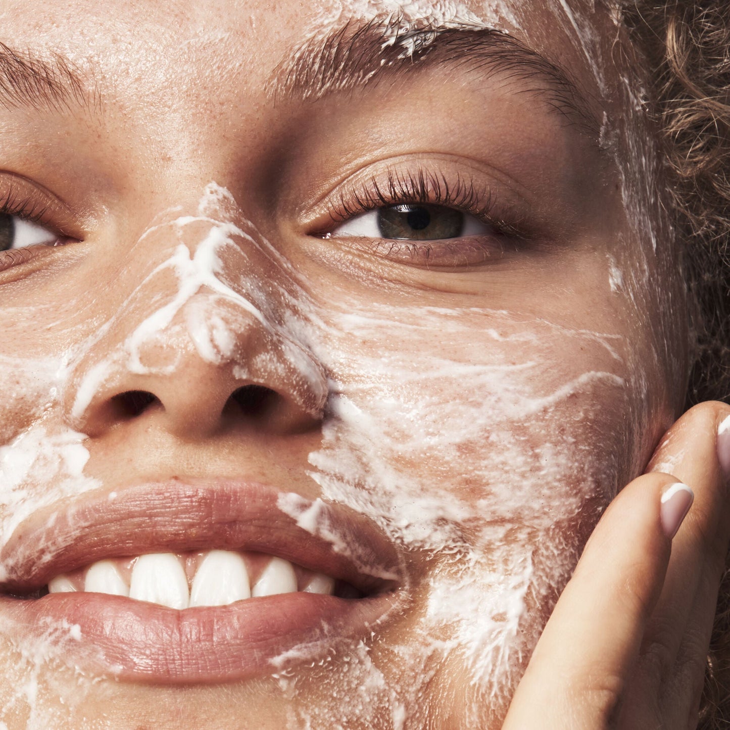 Close-up of a woman's face with a skincare product applied to her skin.